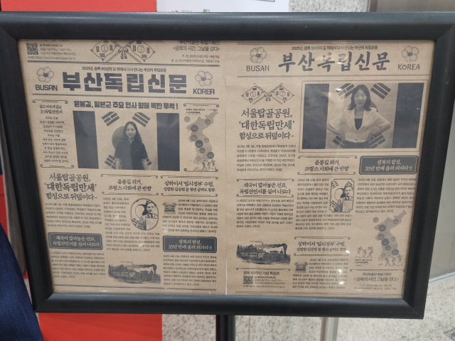 영화 ‘밀정’ 속 한 장면처럼, 오래된 태극기 앞에서 사진을 찍으면 체험자의 얼굴이 나온 독립신문을 기념품으로 챙길 수 있다. 김효정 기자