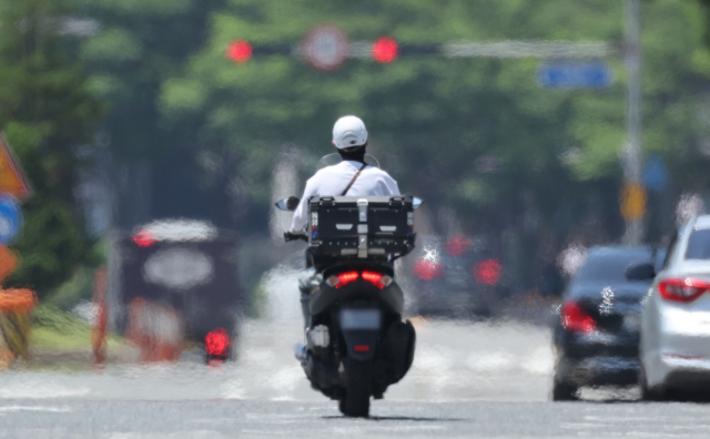 2일 부산 해운대구 벡스코 인근에서 한 배달 오토바이가 지열로 달궈진 도로를 지나가고 있다. 정종회 기자 jjh@