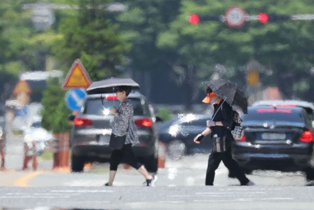 부산지역에 폭염특보가 이어진 지난 2일 해운대구 벡스코 인근 도로에서 시민들이 지열로 아지랑이가 피어오르는 횡단보도를 건너고 있다. 이날 부산의 밤사이 최저기온은 25.9도로, 올 여름 첫 열대야 현상이 나타나 1914년 이후 111년 만에 가장 이른 열대야를 기록했다. 정종회 기자 jjh@
