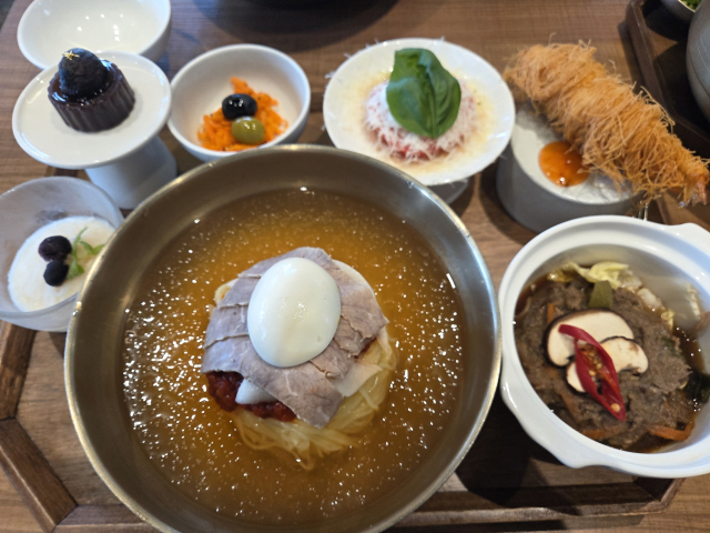 물밀면과 한우 암소 불고기, 카다이프 새우 튀김 등 쟁반 가득 차려진 밀면 반상이 먹음직스럽다.