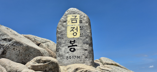 국립공원 지정이 추진되고 있는 금정산 정상 고당봉 표지석에 누군가가 ‘금정’이라는 글자가 적힌 종이를 본드로 붙여 표지석을 훼손하는 일이 벌어졌다. 현재 종이는 제거됐지만 접착제 등 잔여물이 남았고 일부 글자가 벗겨지는 등 피해가 발생했다. (사)범시민 금정산보존회 제공