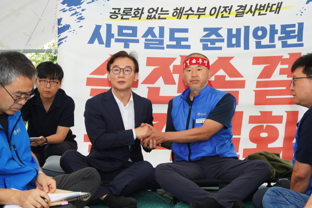 전재수 해양수산부 장관 후보자가 17일 오후 서울 여의도 국회 앞에서 해수부 부산 이전 반대 단식 투쟁 중인 윤병철 공무원노조 해수부지부 위원장과 만나 대화하며 손을 잡고 있다. 윤 위원장은 이날 전 후보자와의 만남에서 단식 투쟁 중단을 선언했다. 해수부 제공