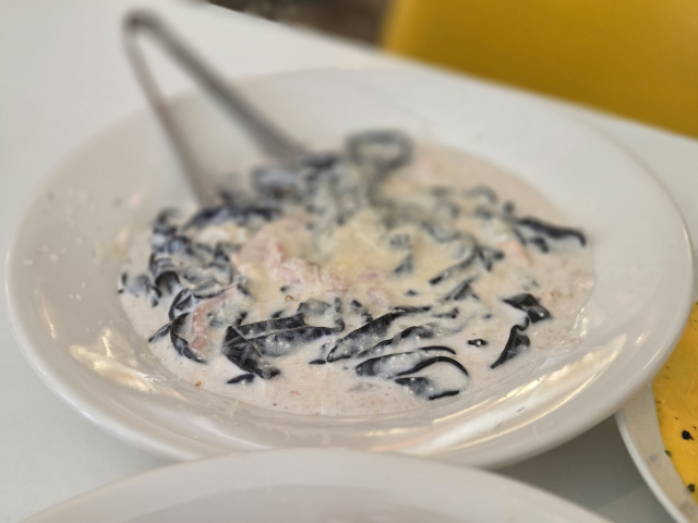 얇고 넓적한 면을 사용해 크림 소스를 듬뿍 머금은 명란 먹물 탈리아텔레.