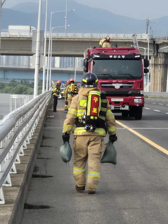 8일 오후 3시 10분께 부산 북구 구포동 강변도로에서 화물차에서 산성 물질을 담은 통이 떨어져 누출되는 사고가 일어났다. 부산소방재난본부 제공