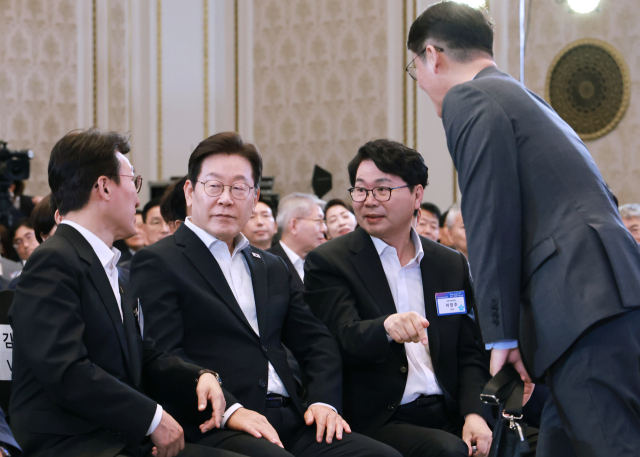 이재명 대통령이 13일 청와대 영빈관에서 열린 국정기획위원회 국민보고대회를 마치며 김민석 국무총리(왼쪽), 이한주 국정기획위원장과 논의하고 있다. 연합뉴스