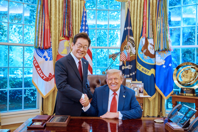 이재명 대통령이 25일(현지 시간) 미국 워싱턴DC 백악관 오벌 오피스에서 열린 한미 정상회담 뒤 도널드 트럼프 미국 대통령과 악수하며 미소짓고 있다. 연합뉴스