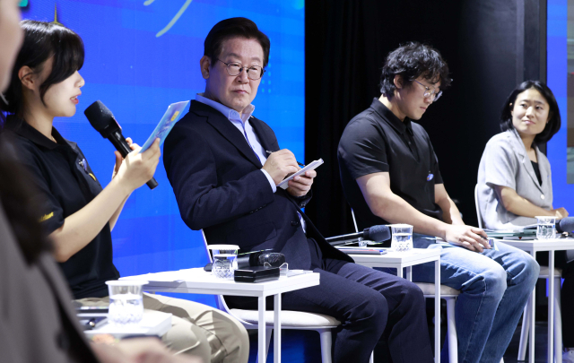 이재명 대통령이 19일 서울 마포구 구름아래 소극장에서 열린 2030 청년 소통·공감 토크콘서트에서 참석자 발언을 메모하며 듣고 있다. 연합뉴스