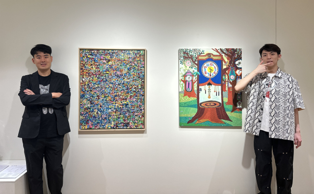 스페이스 토핑에서 열리고 있는 ‘감각, 기록자들’ 전시 초대 작가 황성제·윤진석 작가가 본인 작품 앞에서 포즈를 취했다. 김은영 기자 key66@
