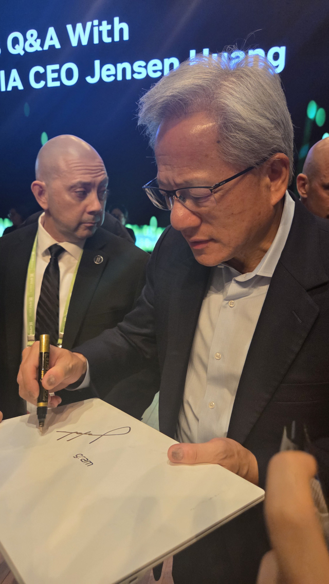 31일 오후 6시께 경주 예술의전당 원화홀에서 열린 기자간담회 후 사인하는 젠슨 황 최고경영자(CEO)의 모습.