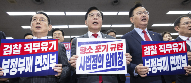 국민의힘 송언석 원내대표(가운데)와 김도읍 정책위의장(왼쪽), 유상범 원내 운영수석부대표가 10일 국회에서 열린 의원총회에서 검찰의 대장동 개발 비리사건 항소 포기를 규탄하는 손팻말을 든 채 규탄 구호를 외치고 있다. 연합뉴스