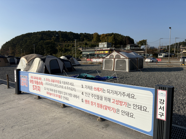 지난 20일 부산 강서구 천성동 천성항 일대에 텐트가 설치된 모습. 구청의 공터 이용 수칙 안내 현수막도 걸려 있다. 김준현 기자 joon@