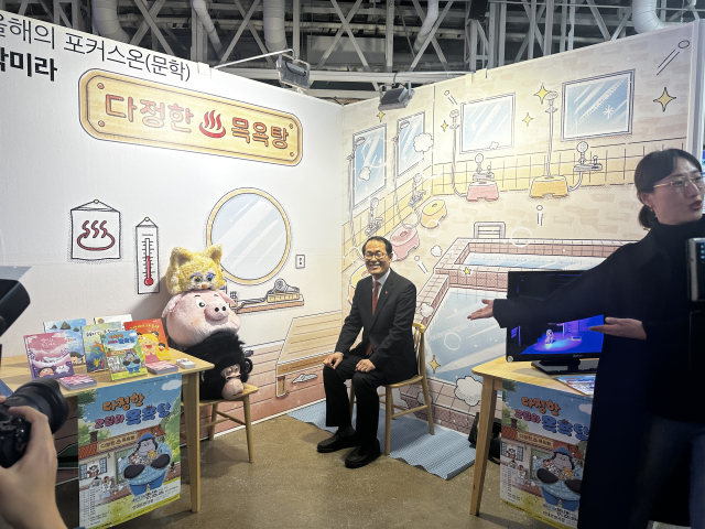 '올해의 포커스온' 문학 부문 지원을 받은 박미라(오른쪽) 작가 부스를 방문한 이준승 부산시 행정부시장이 포토존에 앉아 기념 촬영을 하고 있는 모습. 김은영 기자 key66@