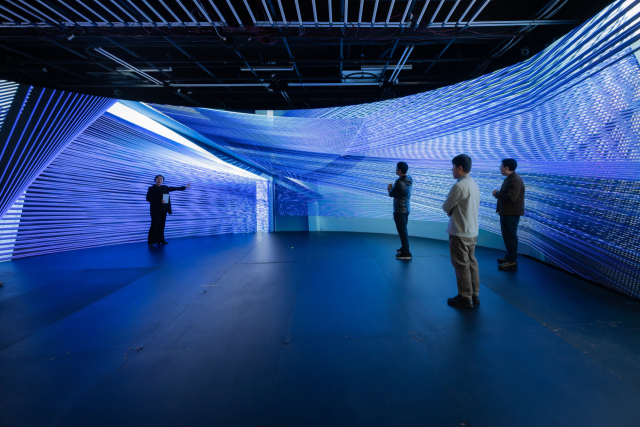 다원예술 그룹 ‘단잠’(DANJAM)이 25일 오후 부산 해운대구 부산영화촬영스튜디오 1층 XR테크랩에서 ‘슈퍼포지션’(SuperPosition) 쇼케이스를 열고 있다. 손몽주 작가가 설명하는 화면을 참석자들이 선 채 지켜보고 있다. 손창안 작가 제공