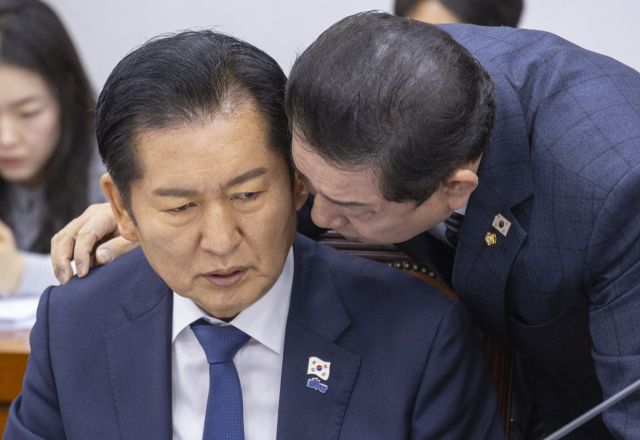 더불어민주당 정청래 대표와 김병기 원내대표가 27일 국회에서 열린 국방위원회 전체회의에서 만나 대화하고 있다. 연합뉴스