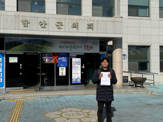 함안군 주민 정주원 씨가 함안군의회 앞에서 주민 서명부를 들어 보이고 있다. 정 씨 제공