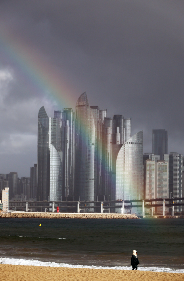 부산기상청은 13일 부산과 울산, 경남 지역에 가끔 비 또는 눈이 내릴 것이라고 전망했다. 사진은 비가 오락가락한 지난 12일 부산 광안리해수욕장에서 해운대구 마린시티를 바라본 하늘에 뜬 무지개. 연합뉴스