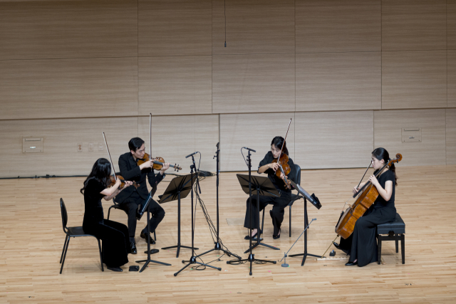 부산시립미술관은 14일 오후 5시 부산 부산진구 부산콘서트홀 챔버홀에서 '이우환 공간 10주년 기념 연주회: 보는 소리, 듣는 빛'을 개최했다. 사진은 위르크 프라이의 첫 '현악 사중주'를 연주하는 화음챔버오케스트라 단원들 모습. 부산시립미술관 제공