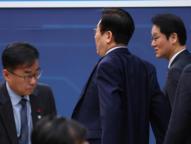 이재명 대통령이 17일 정부세종컨벤션센터에서 열린 산업부·중기부·지재처 업무보고를 마친 뒤 기지개를 켜며 회의장을 나서고 있다. 연합뉴스