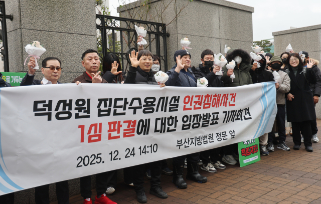 지난달 24일 부산 연제구 부산지방법원 앞에서 덕성원 피해자들이 손해배상 청구 판결에 대한 기자회견을 마치고 손을 흔들고 있다. 이재찬 기자 chan@