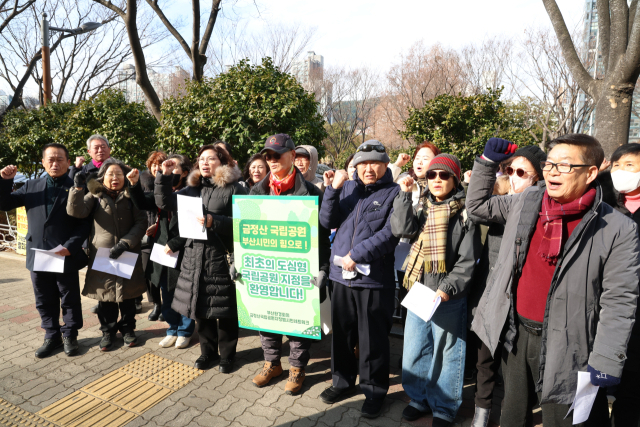 2025년 마지막 날일인 31일 부산시청 후문에서 금정산국립공원지정범시민운동네트워크 등 부산 지역 시민·환경단체 관계자들이 금정산 국립공원 지정을 위해 939일 간의 1인 시위를 마무리한 유진철 공동집행위원장을 축하하고 있다. 김종진 기자 kjj1761@