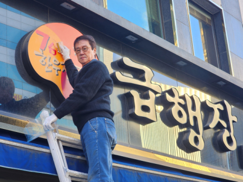 ‘급행장’ 손재권 대표가 지난 2일 사다리를 타고 올라가 간판에 ‘76년 전통 한우전문점’이라는 문구를 새로 붙이고 있다.