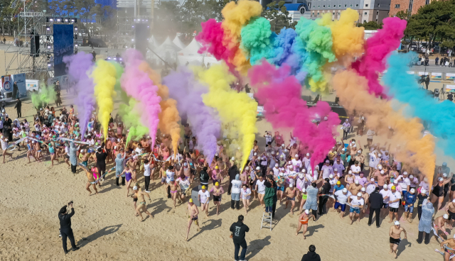 참가자들이 친환경 컬러 파우더를 공중에 뿌리며 바다로 뛰어드는 ‘컬러풀 다이브’를 하고 있다. 김종진 기자 kjj1761@