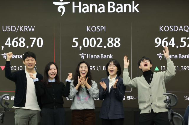 코스피가 장중 5000을 넘어선 가운데 22일 오전 서울 중구 하나은행 딜링룸에서 딜러들이 기뻐하고 있다. 연합뉴스