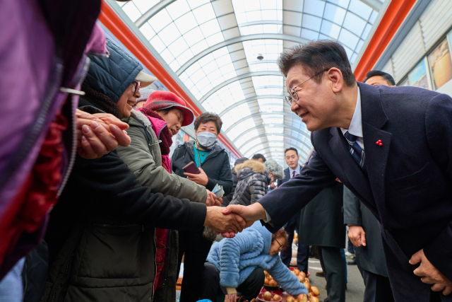 이재명 대통령이 지난 23일 울산 울주군 온양읍 남창옹기종기시장을 방문해 시장 상인과 인사를 하고 있다. 연합뉴스