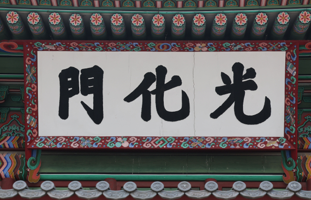 2022년 6월 광화문 현판 모습. 현판의 '광'(光) 자와 '화'(化) 자 사이에 미세한 금이 보인다. 이렇게 균열이 발생하면서 정확한 복원이 아니라는 지적이 제기됐고 광화문 현판을 둘러싼 논쟁도 다시 본격화됐다. 이후 사료 검토를 거쳐 2023년 10월 검정 바탕에 금색 글씨의 한자 현판이 새로 설치됐다. 연합뉴스