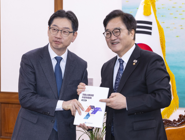 우원식 국회의장(오른쪽)이 4일 국회에서 김경수 지방시대위원회 위원장을 만나 국회에서 만든 지방소멸대응 보고서를 전달하고 있다. 연합뉴스