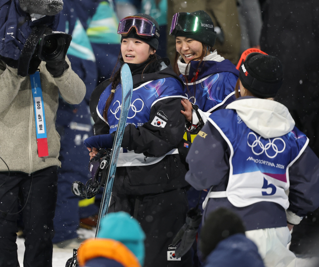 12일(현지시간) 이탈리아 리비뇨 스노파크에서 열린 2026 밀라노·코르티나담페초 동계 올림픽 스키 스노보드 여자 하프파이프 결선에서 최가온이 90.25점을 획득해 금메달을 획득한 뒤 미국의 클로이 김으로부터 축하를 받고 있다. 연합뉴스