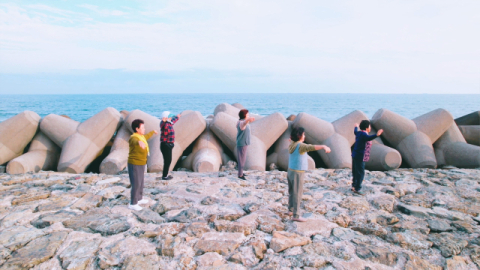 문동마을 주민들이 바닷가 테트라포드 앞에서 ‘파도 치유 체조’를 시연하고 있다. 문동생활권 어촌신활력증진사업 앵커조직 제공