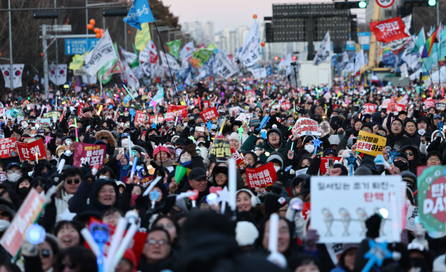 윤석열 대통령 탄핵소추안이 가결된 2024년 12월 14일 서울 여의도 국회 앞에서 열린 탄핵 촉구 집회에 참석한 시민들이 탄핵이 가결되자 환호하고 있다. 연합뉴스