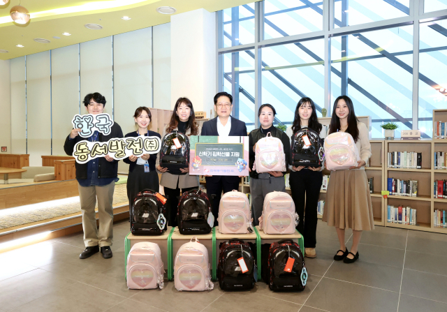 권명호 한국동서발전 사장(가운데) 및 직원들이 새학기 책가방 꾸러미를 들고 기념사진을 찍고 있다. 동서발전 제공