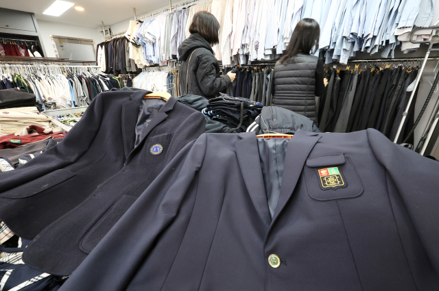 지난 23일 관내 학교와 졸업생에게 교복을 기증받아 필요로 하는 주민에게 저렴하게 판매하는 서울 송파구 ‘나눔교복매장’을 찾은 학부모가 교복 등을 살펴보고 있다. 연합뉴스