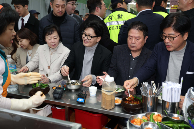 한동훈 국민의힘 전 대표가 27일 오후 대구 서문시장을 찾은 자리에서 일행들과 국수를 먹고 있다. 연합뉴스