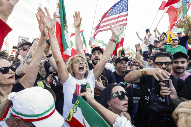 지난 달 28일(현지 시간) 미국 캘리포니아주 로스앤젤레스에서 이란 공격을 지지하는 시위대가 성조기와 이란 국기를 흔들고 있다. EPA연합뉴스