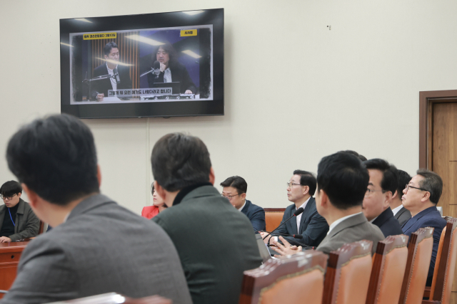 12일 국회에서 열린 국민의힘 최고위원회의에서 김민수 최고위원이 발언하는 가운데 ‘공소 취소 거래설’을 언급한 유튜브 채널 ‘김어준의 겸손은힘들다 뉴스공장’ 영상이 나오고 있다. 연합뉴스