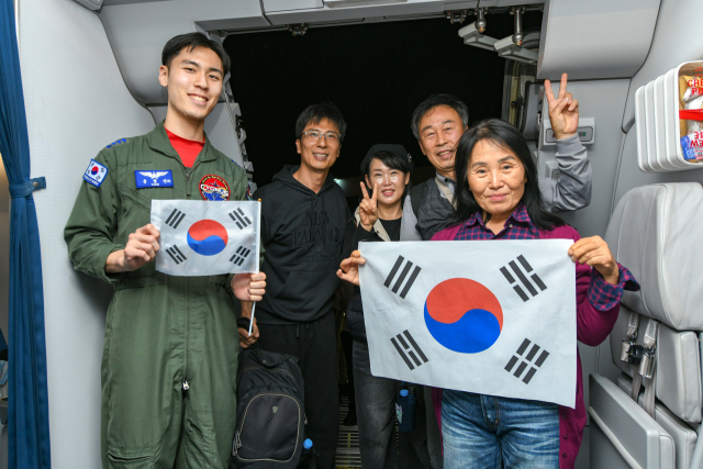 미국·이스라엘과 이란 간 전쟁으로 중동에 고립됐던 국민들이 정부가 투입한 군 수송기를 타고 귀국했다. 외교부와 국방부는 공군 다목적 공중급유 수송기 1대가 14일(현지 시간) 사우디아라비아 리야드에서 한국인 204명과 외국 국적 가족 5명, 일본 국민 2명 등 총 211명을 태우고 이륙했다고 밝혔다. 이번 작전으로 공군 수송기에 탑승한 국민들이 태극기를 들어 보이고 있다. 연합뉴스