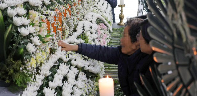 22일 대전시청에 마련된 대전 안전공업 화재 희생자 합동분향소에서 한 유족이 아들 이름이 적힌 위패를 만지고 있다. 연합뉴스