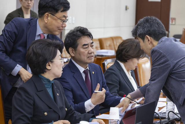 24일 국회에서 열린 국회 행정안전위원회 법안심사제1소위원회에서 위원장인 더불어민주당 윤건영 의원(오른쪽)과 국민의힘 행안위 간사인 서범수(왼쪽) 의원과 이성권 의원(가운데)이 부산 글로벌허브도시특별법 처리와 관련해 대화하고 있다. 연합뉴스