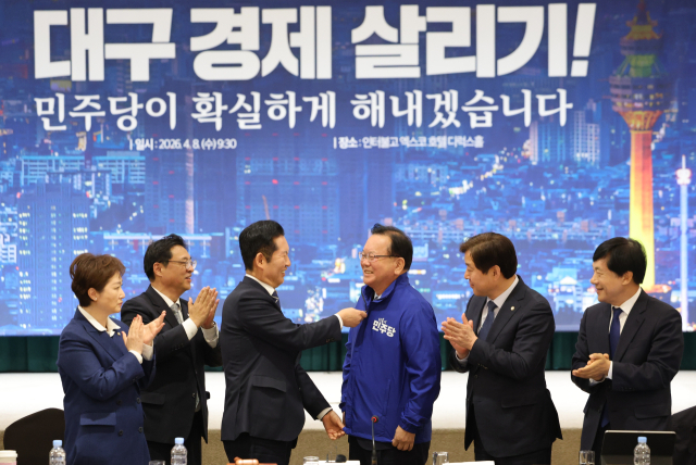 더불어민주당 정청래 대표가 8일 대구 북구 인터불고 엑스코 호텔에서 열린 더불어민주당 현장 최고위원회의에서 대구시장 후보인 김부겸 전 국무총리에게 당 점퍼를 입혀주고 있다. 연합뉴스