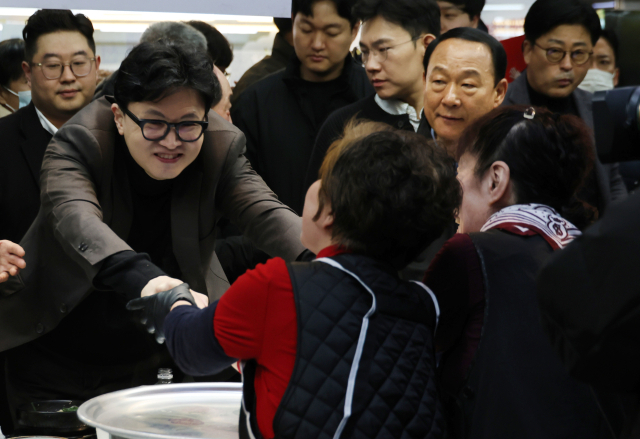 한동훈 전 국민의힘 대표가 3월 7일 부산 북구 구포시장의 한 국밥집을 찾아 상인과 인사하고 있다. 연합뉴스