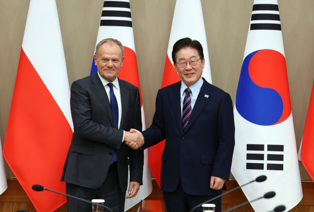 이재명 대통령과 도날트 투스크 폴란드 총리가 13일 청와대에서 확대 정상회담에 앞서 악수하고 있다. 연합뉴스