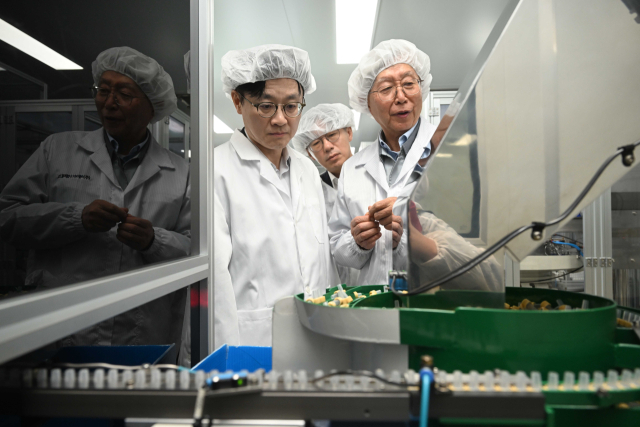 김정관(앞줄 오른쪽 두 번째) 산업통상부 장관이 13일 경기도 안산에 위치한 주사기, 수액제 포장재를 생산하는 에이디켐테크 공장을 방문, 수급 상황을 점검하고 있다. 공동취재단 제공