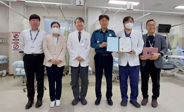 통영경찰서 성강운 북신지구대장(오른쪽에서 3번째)이 신속한 대응으로 인명구조에 협력한 새통영병원 박철현 응급실장에게 감사패를 전달했다. 통영경찰서 제공