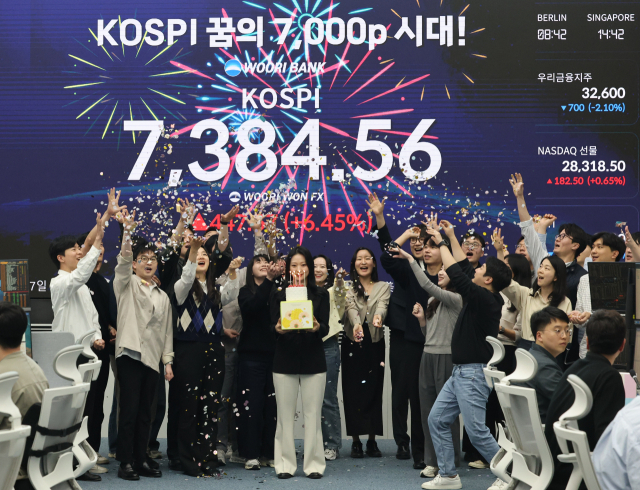 코스피가 사상 처음으로 종가 기준 7000선을 돌파하며 장을 마친 6일 서울 중구 우리은행 본점 딜링룸에서 직원들이 축하 세리머니를 하고 있다. 연합뉴스