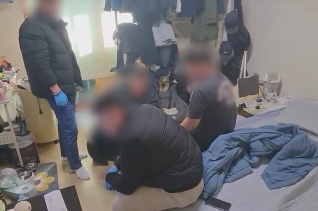 먀약류인 대마를 외국에서 운반한 혐의를 받는 한 피의자(맨 오른쪽)가 경찰관에게 체포되고 있다. 경남경찰청 제공
