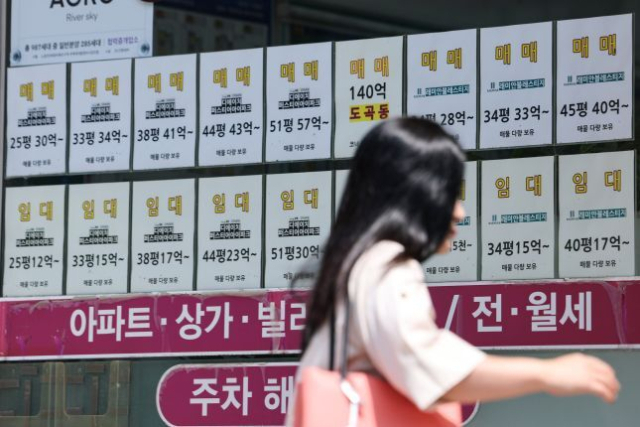 사진은 부동산 중개소 앞을 지나는 시민 모습. 연합뉴스
