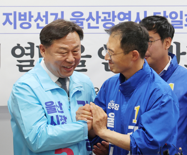 15일 울산시의회 프레스센터에서 더불어민주당 울산시당과 진보당 울산시당이 6·3 지방선거 울산시장 후보 단일화 합의를 발표한 후 민주당 김상욱(오른쪽)·진보당 김종훈 울산시장 후보가 손을 맞잡고 있다. 연합뉴스